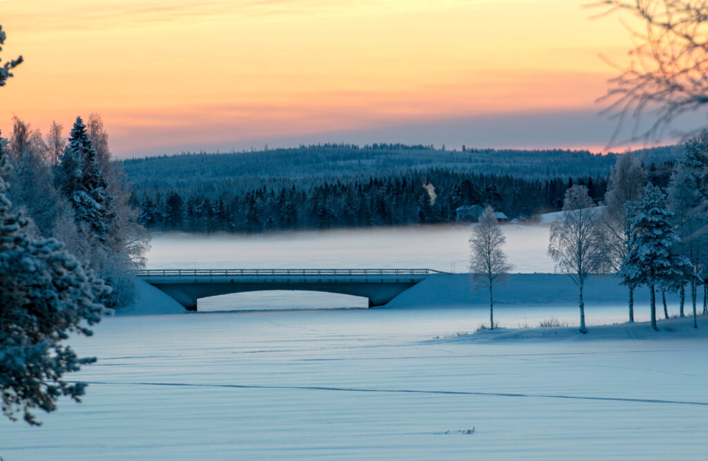 Snötäckt bro över frusen älv i Norsjö. Vinterlandskap i en kommun där intresset för solenergi växer.