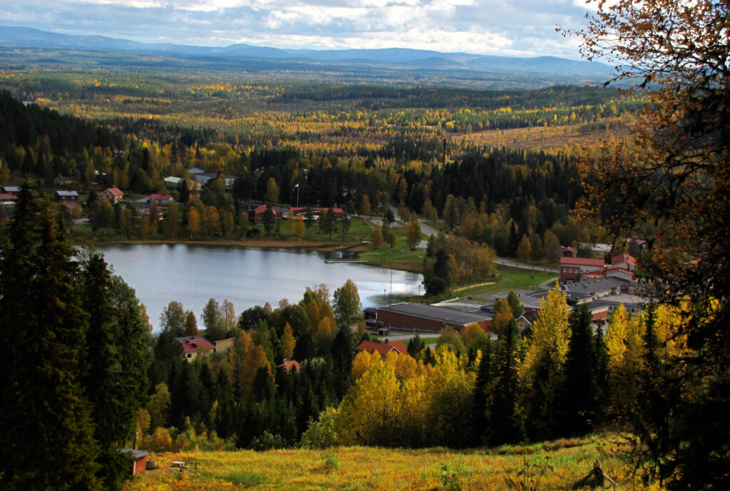 Höstfärgat landskap med sjö och utspridd bebyggelse. En typisk vy från Västerbottens inland, där solceller blir allt vanligare.
