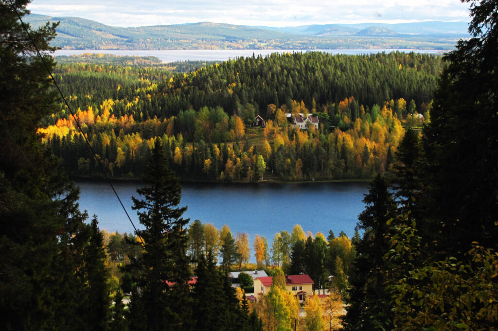 Spegelblank sjö i norrländskt skogslandskap, ett idealiskt område för solenergi i glesbygd och naturnära miljöer.